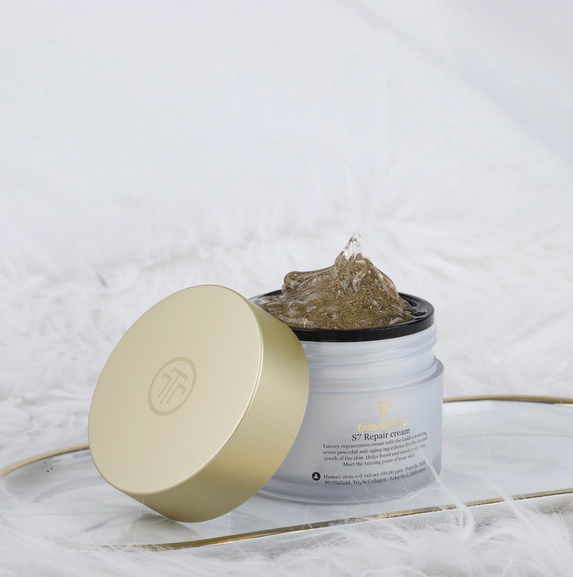 Open jar of s7 repair cream with gold lid on a textured background