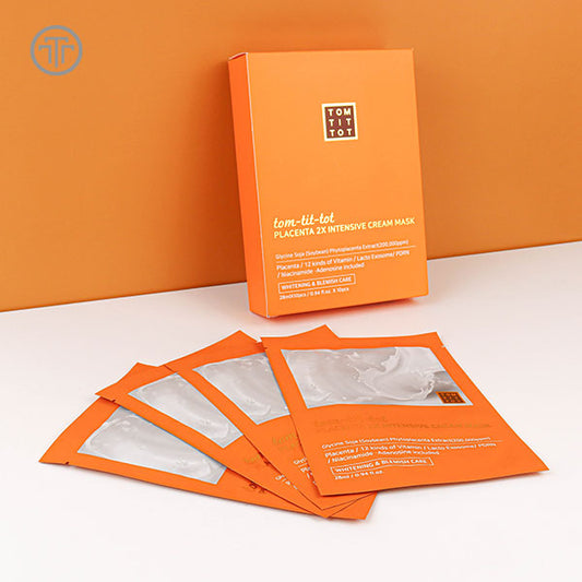 Four orange packets of tom-tit-tot placenta 2x intensive cream mask in front of an orange box.