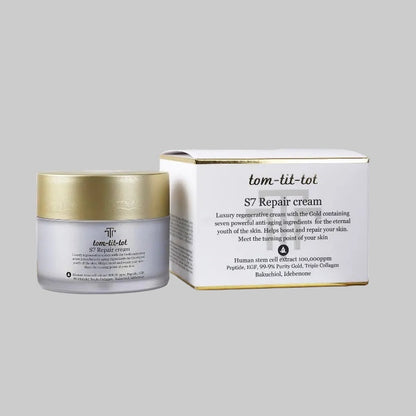 A jar of tom-tit-tot S7 Repair cream next to its white and gold outer packaging box, set against a solid gray background.