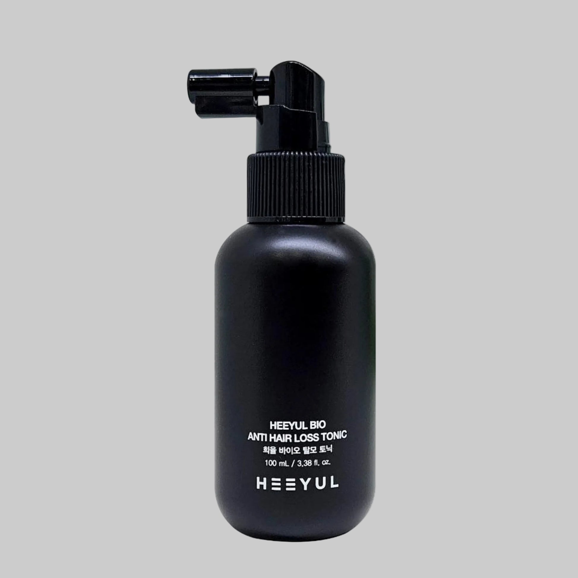 Black pump bottle of Heeyul Bio anti hair loss tonic on a grey background