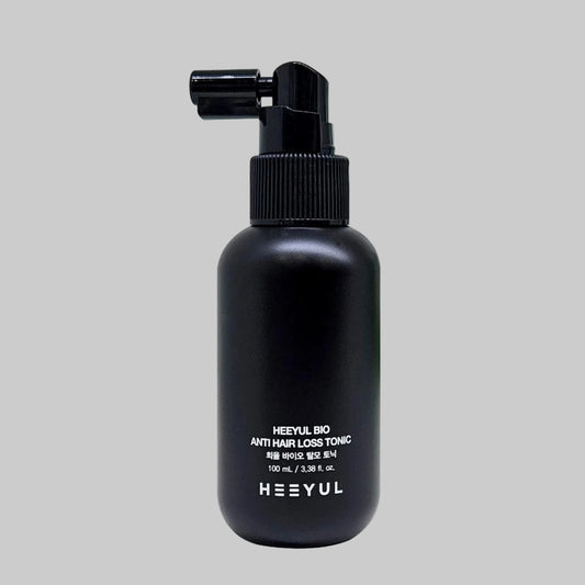 Black pump bottle of Heeyul Bio anti hair loss tonic on a grey background